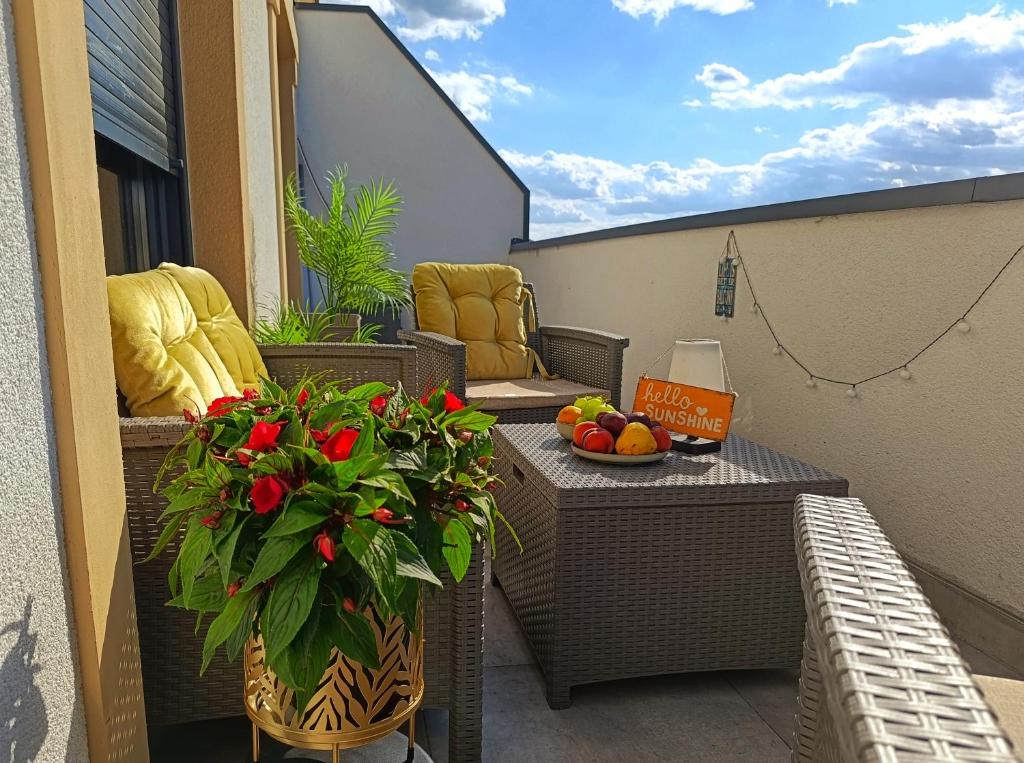 a balcony with a table and flowers on a balcony at "Dolce Vita" Loft in Tuzla