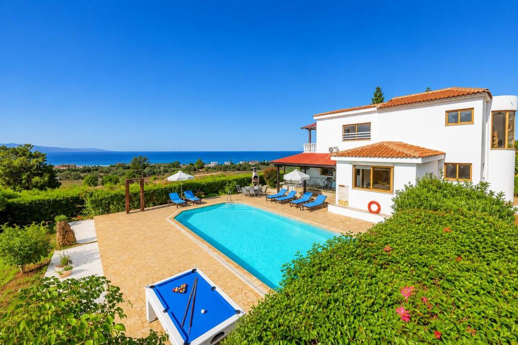 a villa with a swimming pool in front of a house at Villa Argaka Heights in Argaka