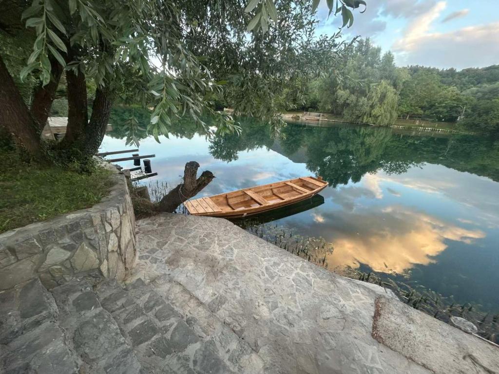 a wooden boat sitting in the middle of a lake at Villa Elaris in Bihać