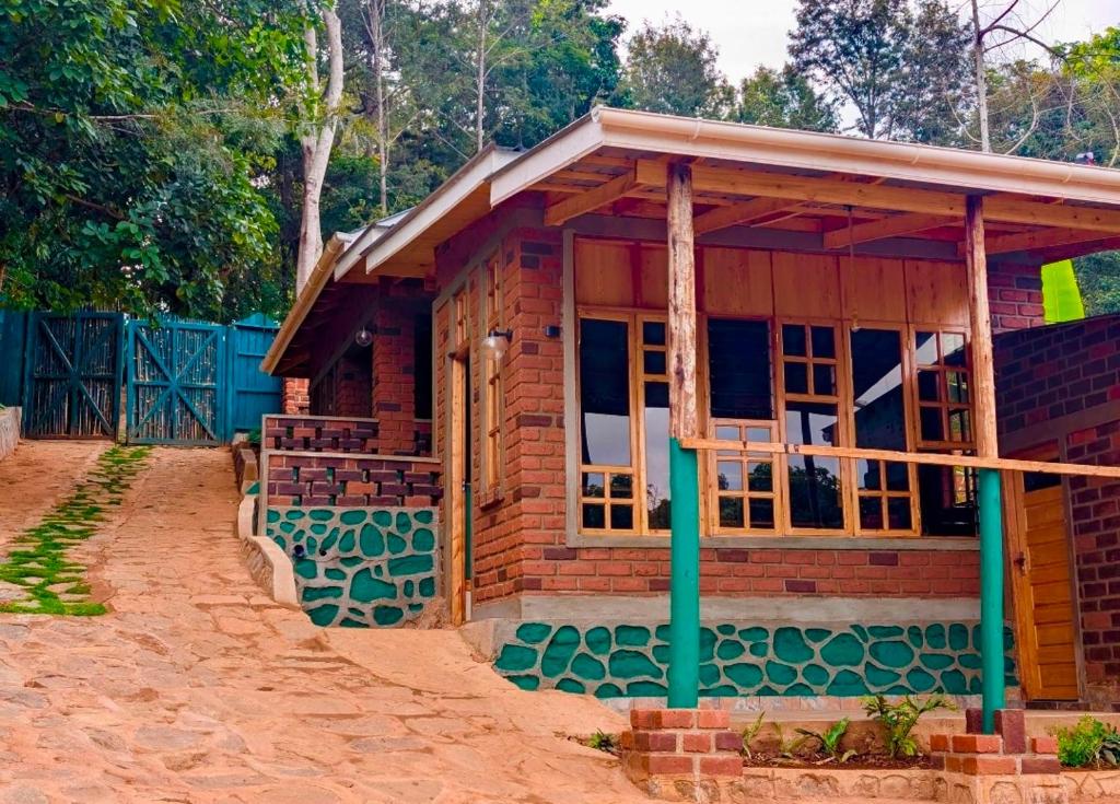 a small brick house with a porch at Kijani Pazuri Cottages in Lushoto