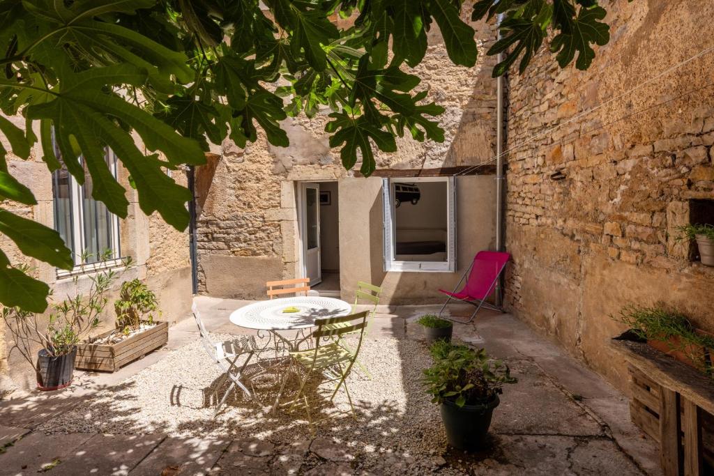 a patio with a table and chairs in a building at Le Patio in Gevrey-Chambertin