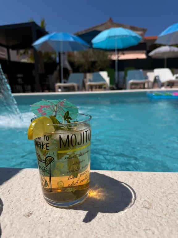 a drink sitting on a table next to a pool at Luxury Blue Sky in Vir