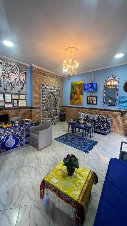 a large living room with blue walls and a chandelier at Dar Bouanani in Asilah