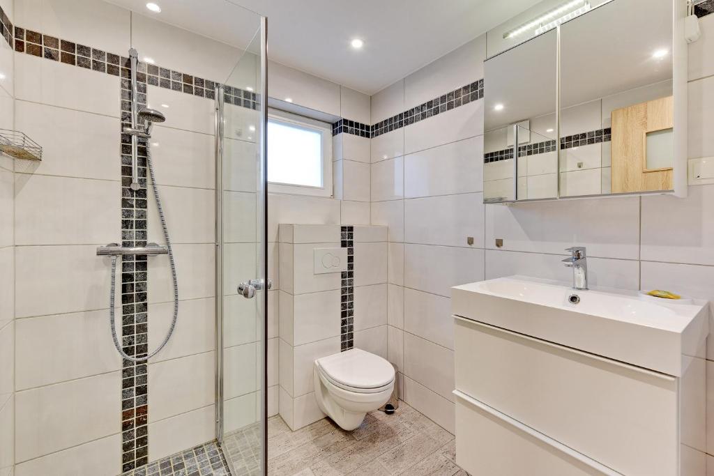 a bathroom with a toilet and a sink and a shower at Villa Arkodes in Gdańsk