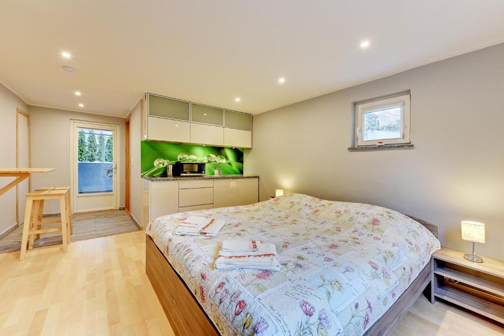 a bedroom with a large bed and a kitchen at Villa Arkodes in Gdańsk
