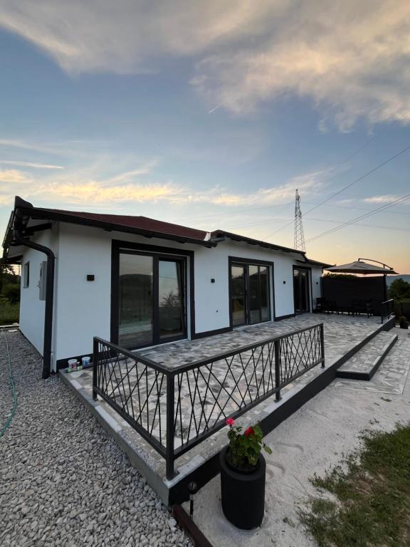 a small white house with a large deck at Villa Noor Visoko in Visoko