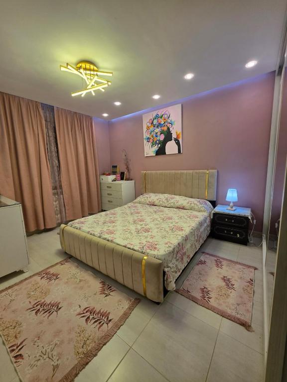 a bedroom with a large bed and two rugs at Ayem house in Souidania
