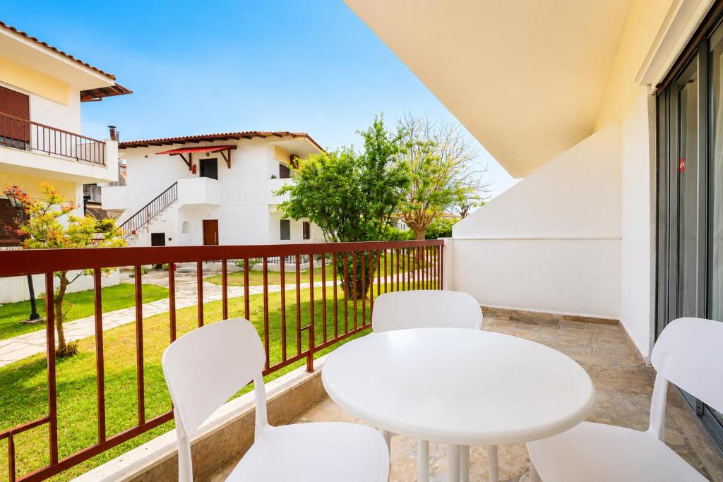 a balcony with a white table and chairs at Ioli Beach in Skala Fourkas