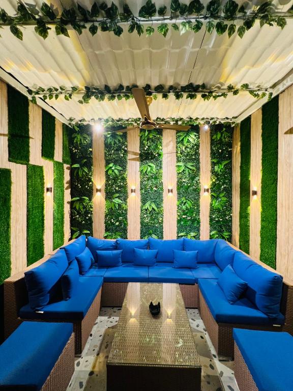a living room with a blue couch and a table at Verdant vista Goa in Cunchelim