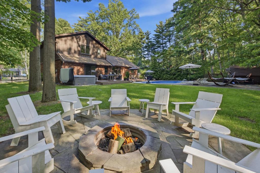 a fire pit in a yard with white chairs at Loma House in Sawyer