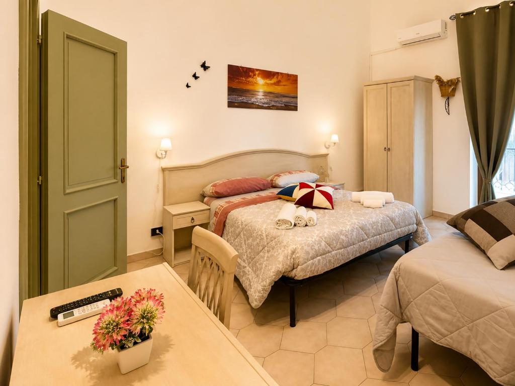 a hotel room with two beds and a table at Bed and Breakfast Station in Brindisi
