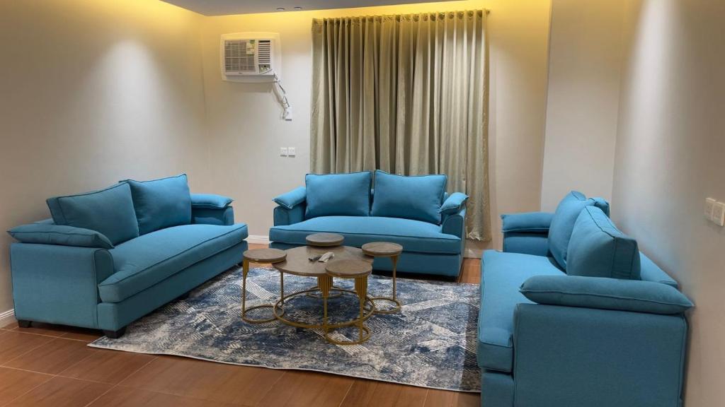 a living room with two blue chairs and a table at شقق احد رفيدة in Ahad Rafidah