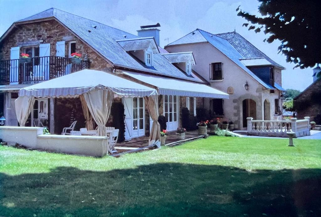 a large house with an umbrella in the yard at La Chouette in Beynat