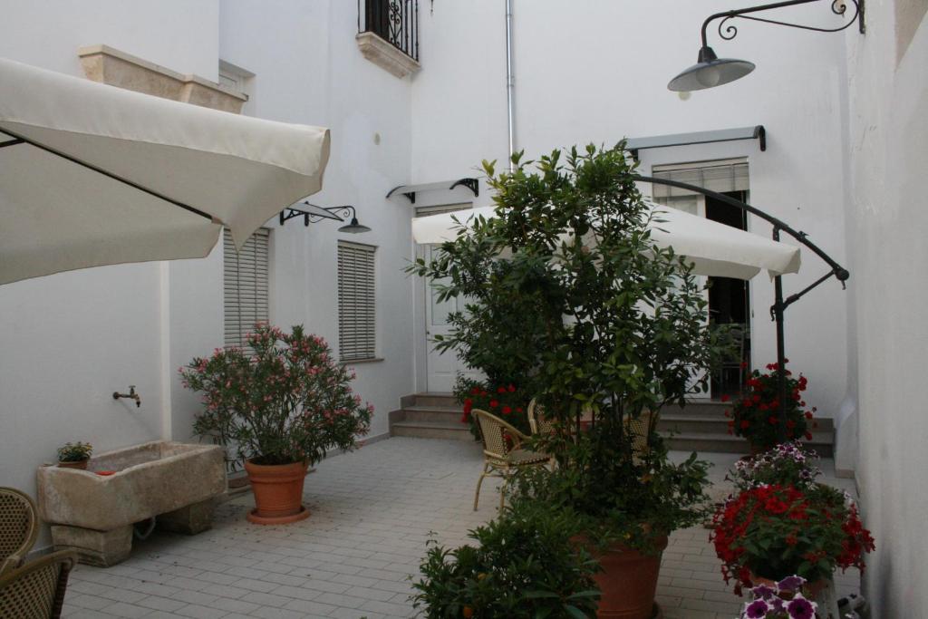 een binnenplaats met potplanten en een wit gebouw bij Corte Lecciso in Leverano