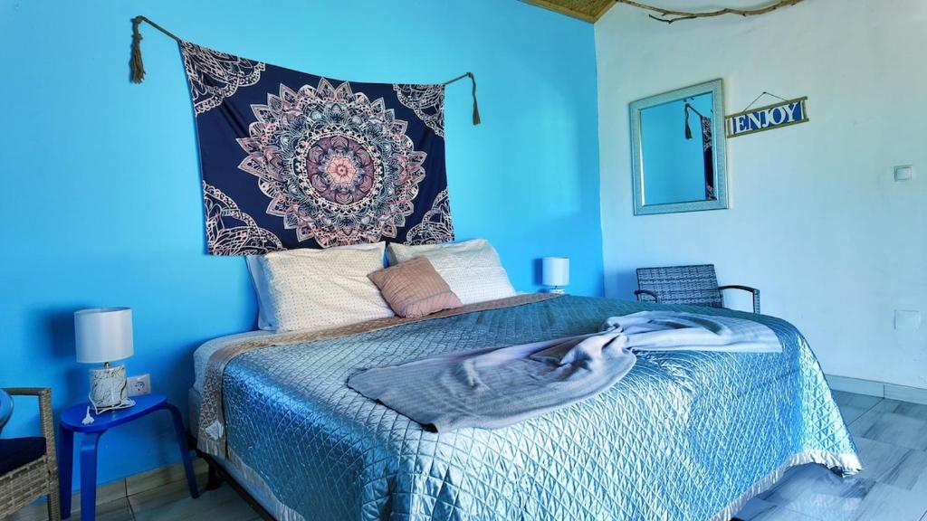 a blue bedroom with a bed with a blue wall at Casa Velho 05 Rodrigues in Órgãos