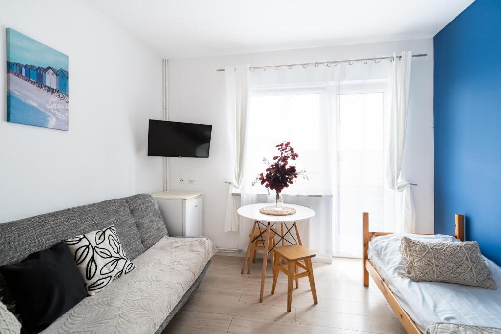 a living room with a couch and a table at Pokoje Złota Plaża in Międzywodzie