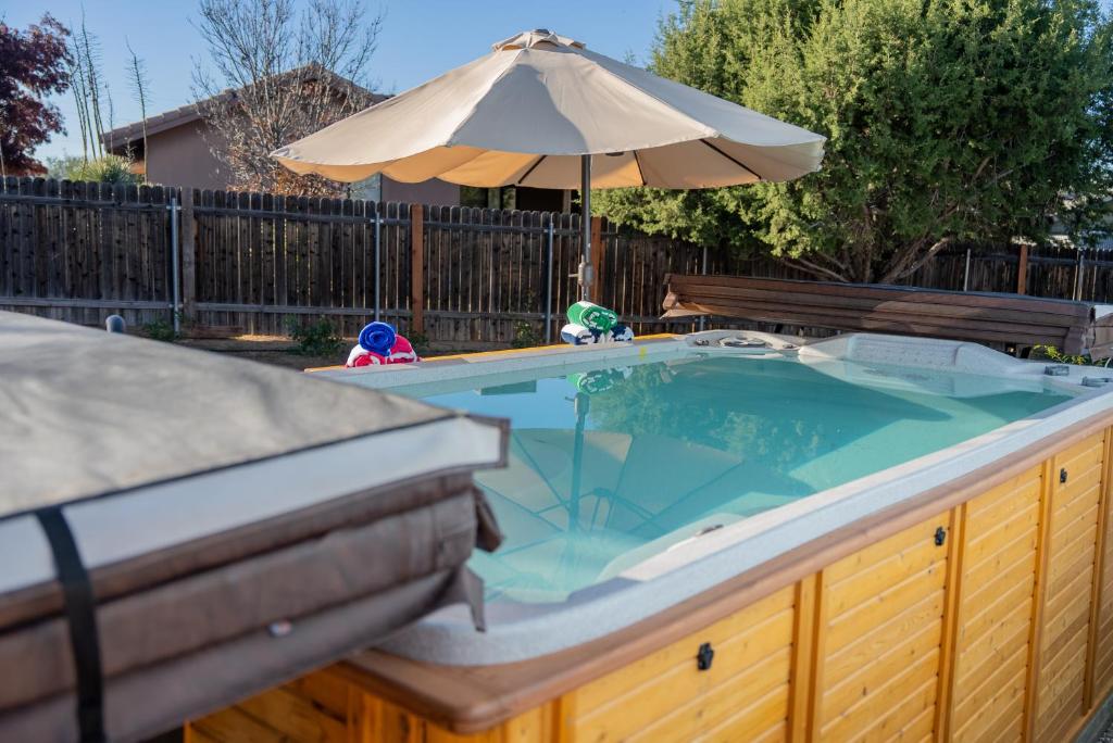 a hot tub in a backyard with an umbrella at Serenity at Rimrock in Rimrock