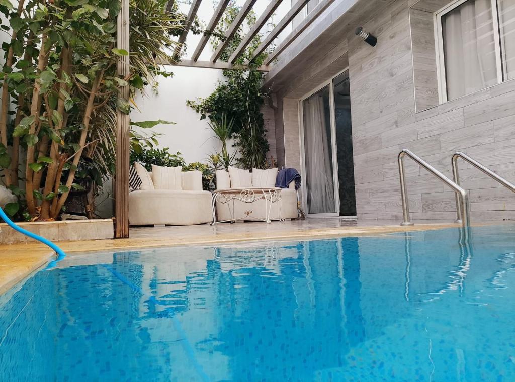 a swimming pool with blue water in a house at Villa Harmonie - Suite Familiale avec Piscine in Khemisset