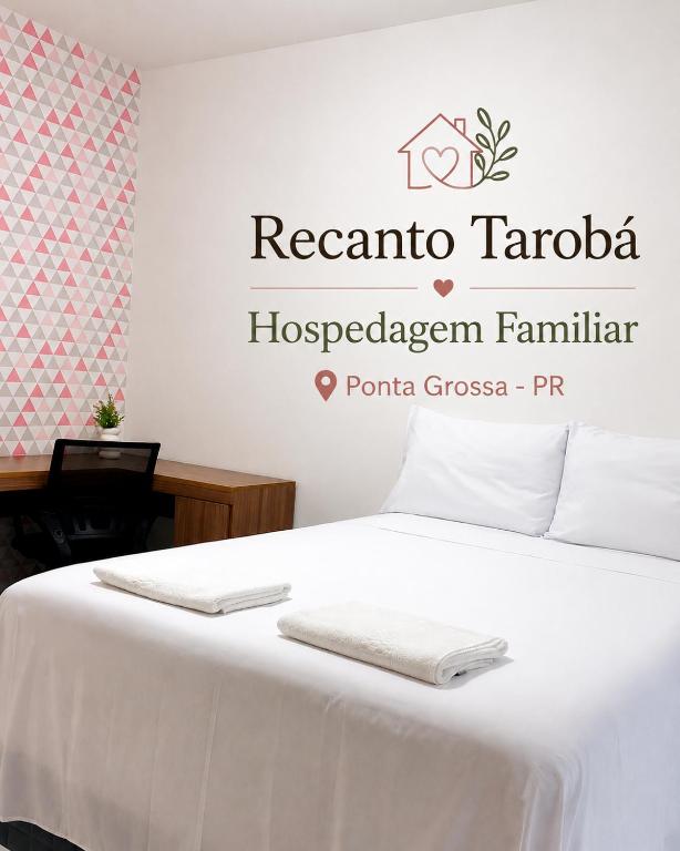 a bedroom with a bed with two towels on it at Recanto Tarobá in Ponta Grossa
