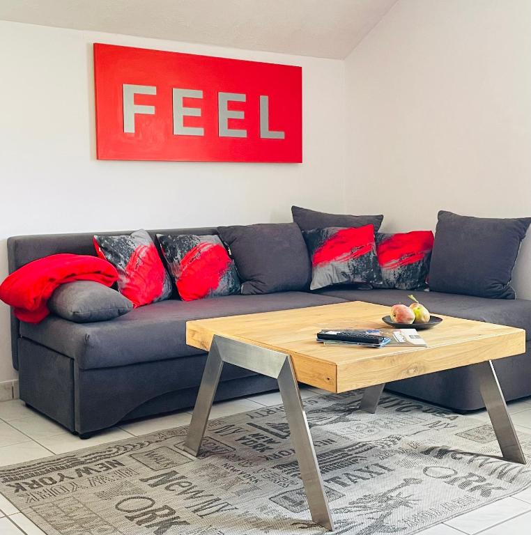 a living room with a blue couch with red pillows at LohainsLodge in Burbach