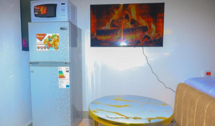 a room with a refrigerator and a table and a picture at Eden Homes in Nairobi