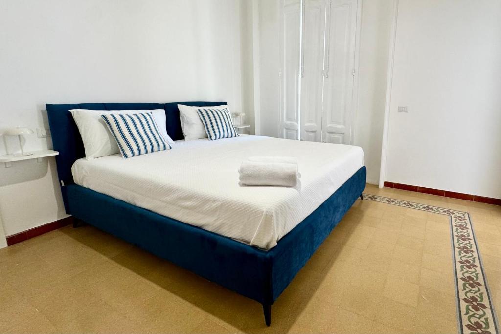 a large bed with a blue frame in a room at Villa Lucia in Torre del Greco