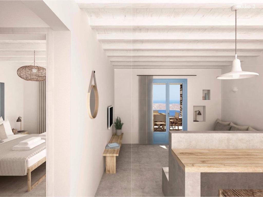 a white bedroom with a bed and a table at Serifos Blue in Rámos