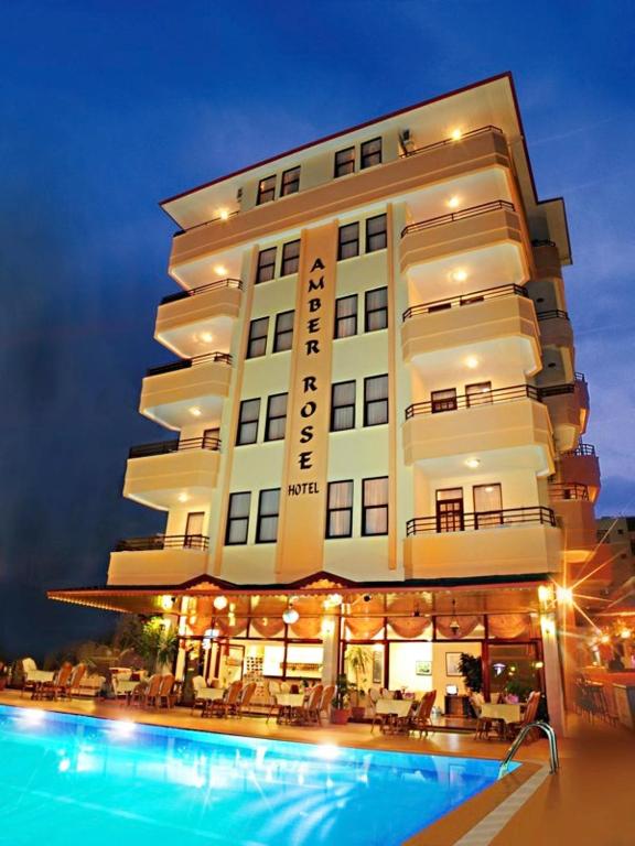 a hotel with a swimming pool in front of it at Amber-Rose Apart Hotel in Alanya