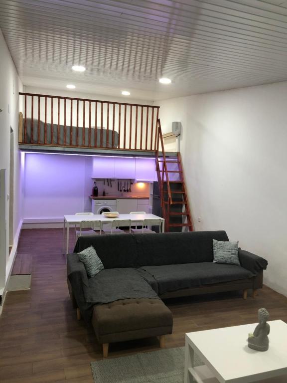a living room with a couch and a staircase at Sky carvoeiro in Mação