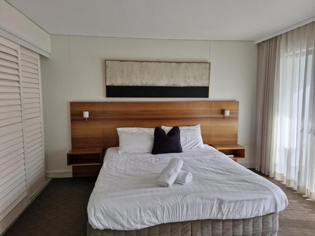 a bedroom with a large bed with two towels on it at 3BR Golfside Villa | Pools, Tennis & Relaxation in Magenta