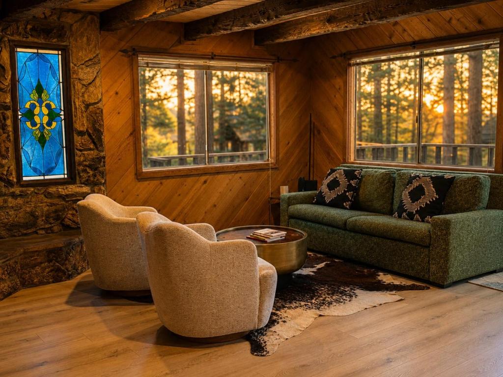 a living room with chairs and a couch and windows at The Hideaway Big Bear in Big Bear Lake