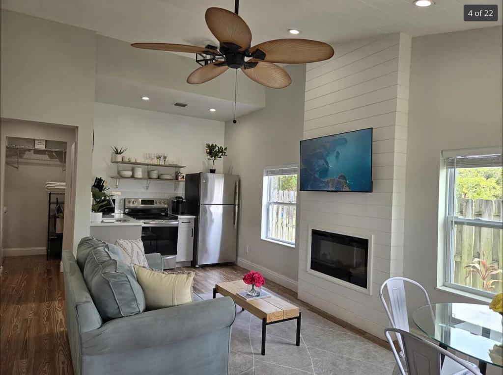 a living room with a couch and a ceiling fan at Endless Summer Cottage - Steps off Atlantic! in Delray Beach