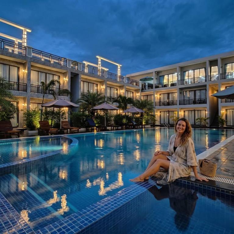 a woman sitting on the edge of a pool at a hotel at Khemra Boutique in Kampot in Kampot