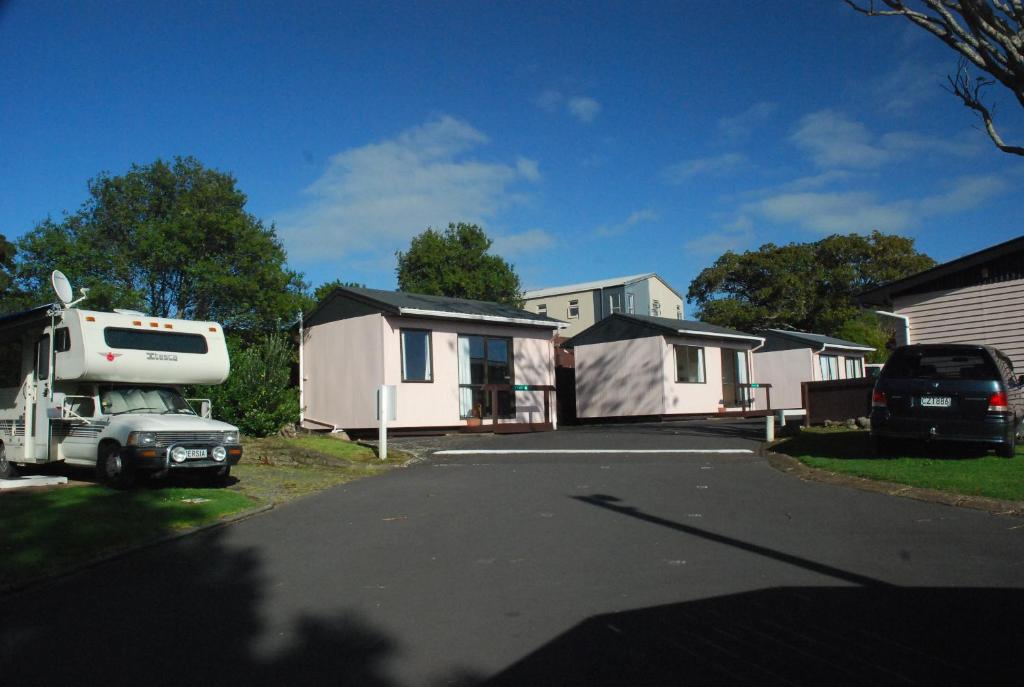 a house with a truck parked in a driveway at Avondale Motor Park in Auckland