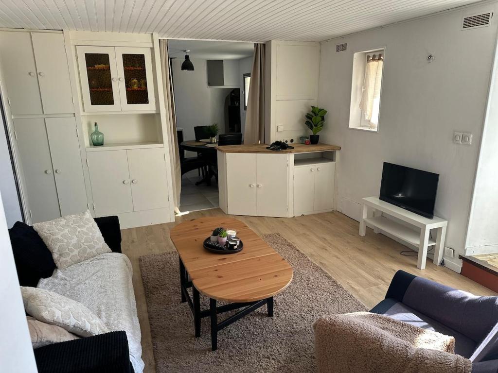 a living room with a coffee table and a kitchen at Maison Icard in Sault-de-Vaucluse