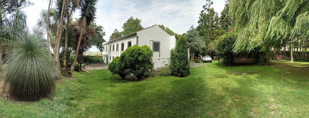 a white house in a yard with trees at Casa dos Santos Historic Azorean Estate in Horta