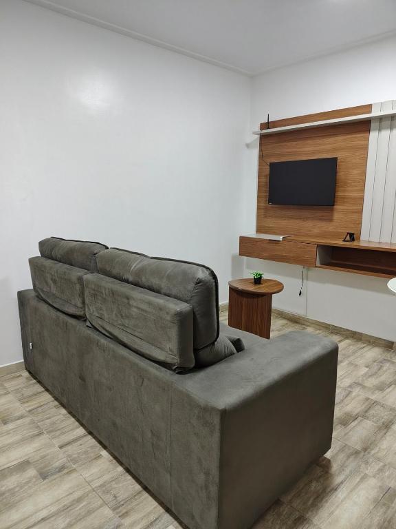 a brown couch in a living room with a tv at Apartamento no Centro de Macapá - Edifício Fernando Dias in Macapá