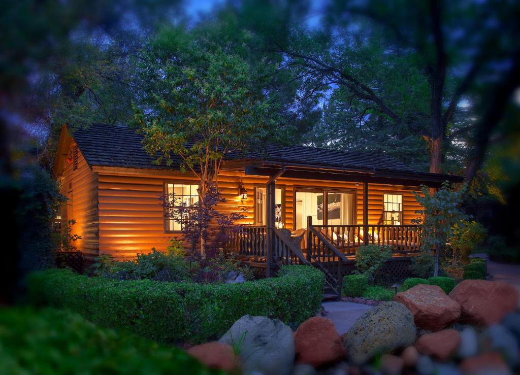 a small log cabin with a porch at night at L'Auberge De Sedona in Sedona