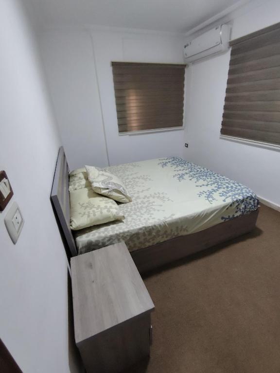 ein kleines Schlafzimmer mit einem Bett und einer Bank in der Unterkunft ريماس 13 in Irbid