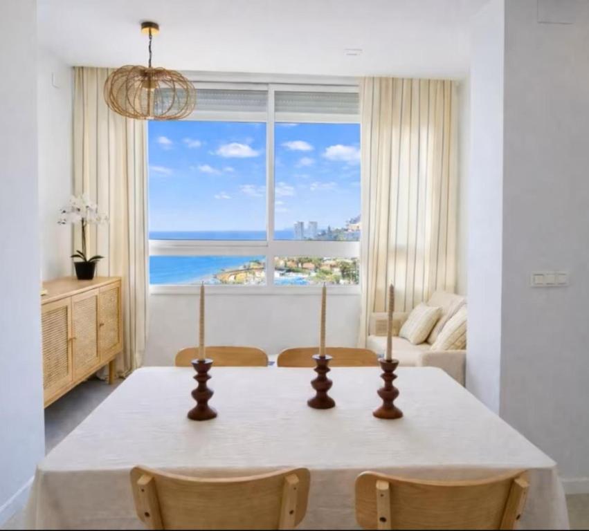 a dining room with a table and a large window at SeaFront Horizon in Sitio de Calahonda