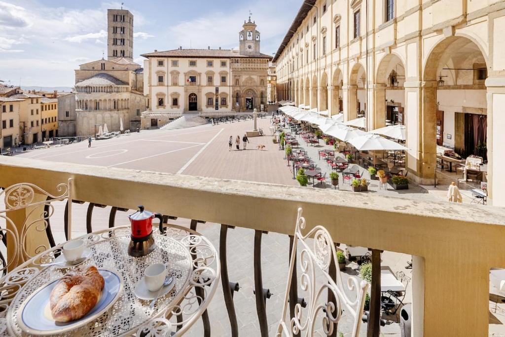 a table with a plate of food on a balcony at Arezzo Centre, Prestigious Apartment with a View in Arezzo
