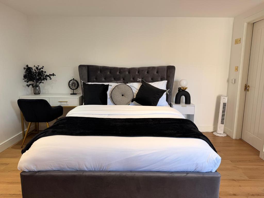 a bedroom with a large bed with a black headboard at Gatwick LUXURY STUDIO FLAT in Crawley