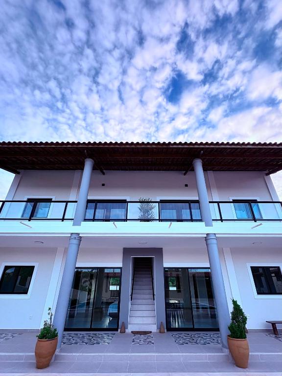 a large white building with columns and a sky at Pousada Recanto dos Passaros in Aracati