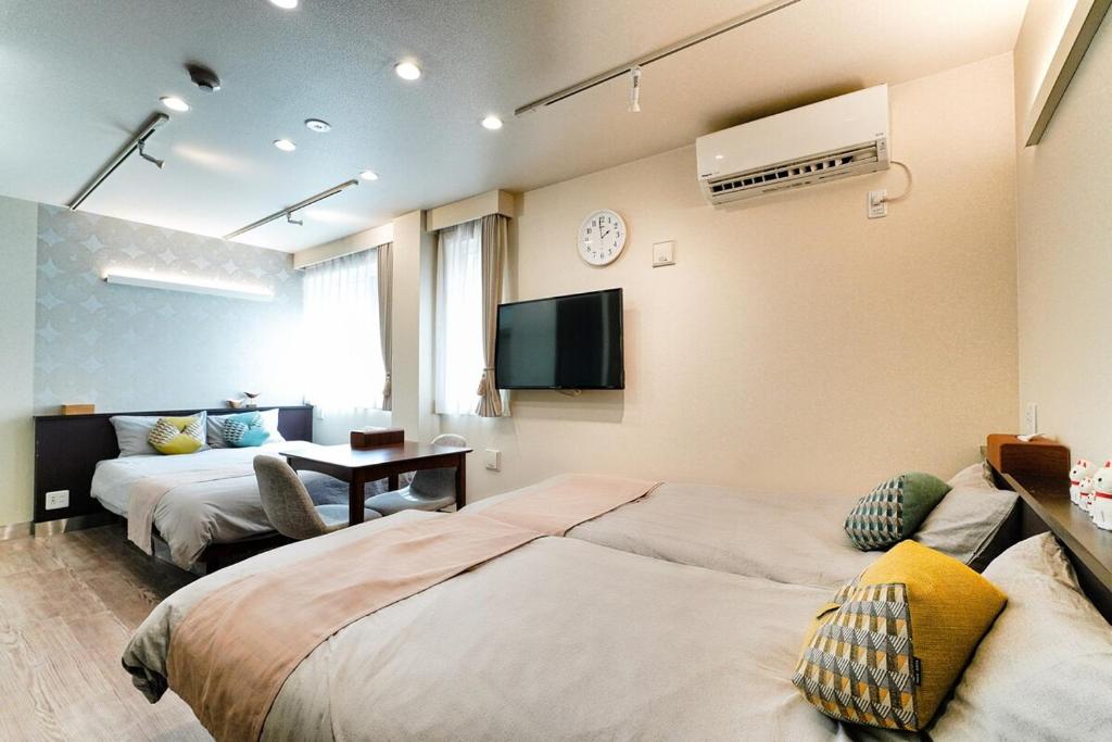 a hotel room with two beds and a tv at Grace Hotel Kyodo odakyu line near shinjuku shibuya in Tokyo