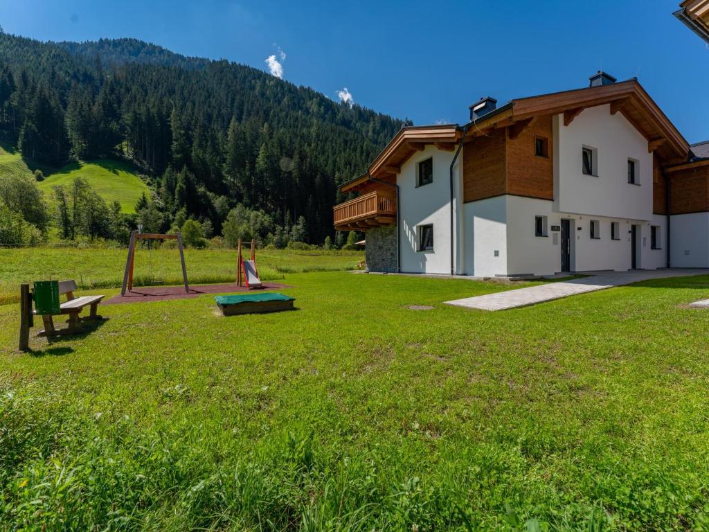 a building with a playground in a grass field at Felsener Wald in Wald im Pinzgau
