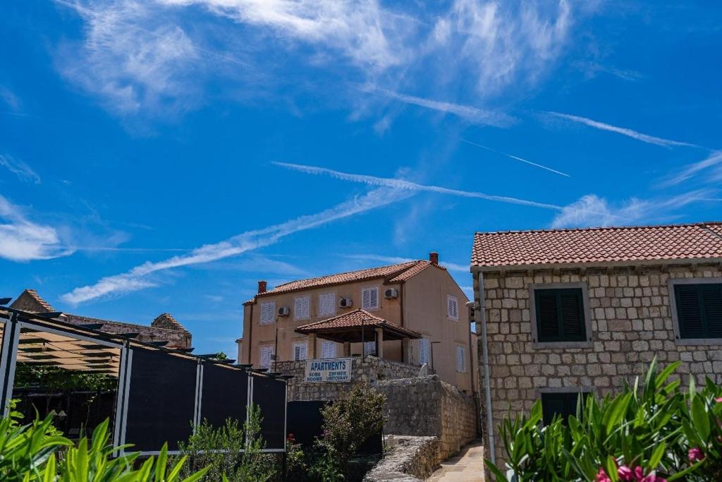 a house with a fence and a blue sky at Apartments and rooms by the sea Slano, Dubrovnik - 2687 in Slano