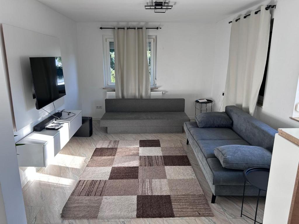 a living room with a couch and a tv at Ferienwohnung Nordheim in Nordheim