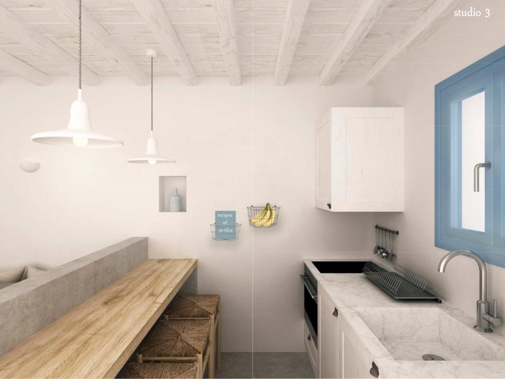 a kitchen with white cabinets and a counter top at Serifos Blue in Rámos