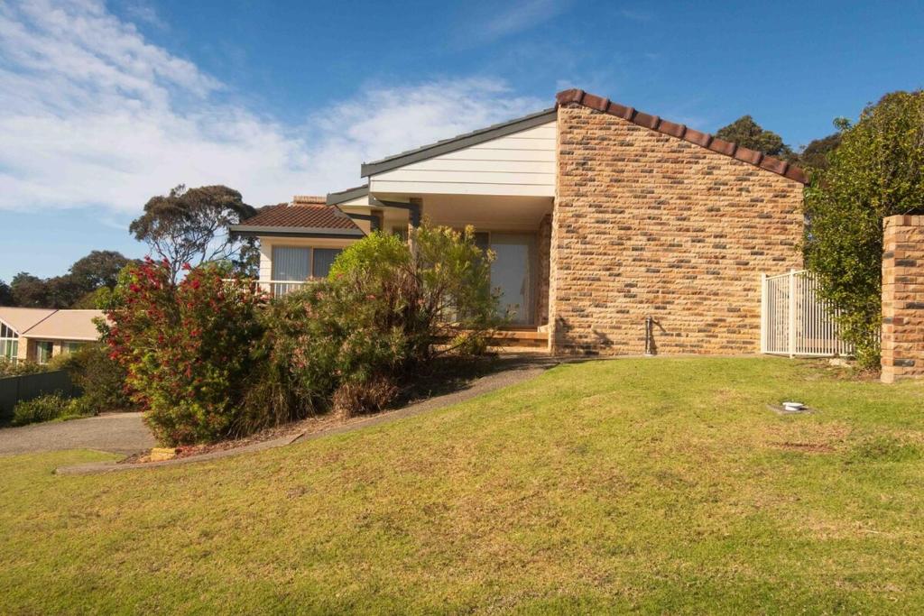 a brick house with a lawn in front of it at Glistening Waters in Tathra
