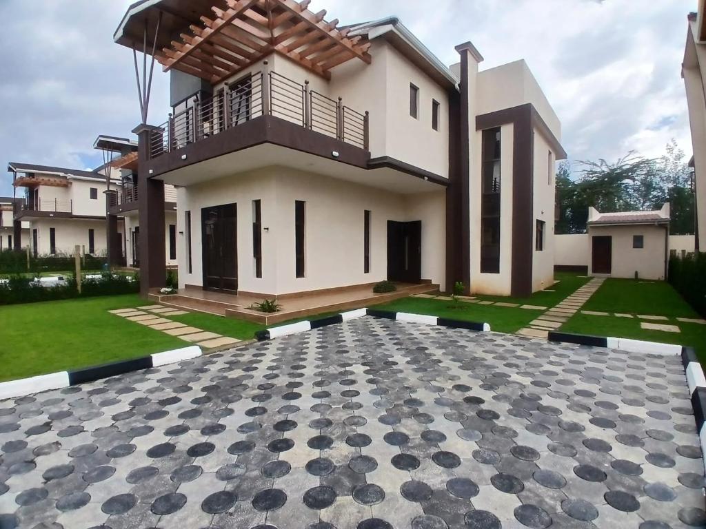 a villa with a courtyard in front of a house at Jaymorgan Villas 4 bedroomed in Nanyuki
